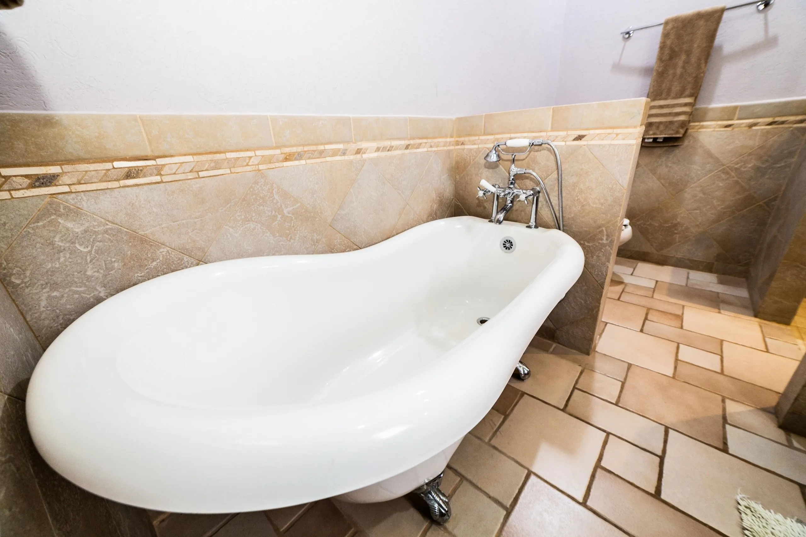 Second-floor bathroom at Casa Dana with a freestanding Victorian claw-foot tub, tiled floor and towel rack