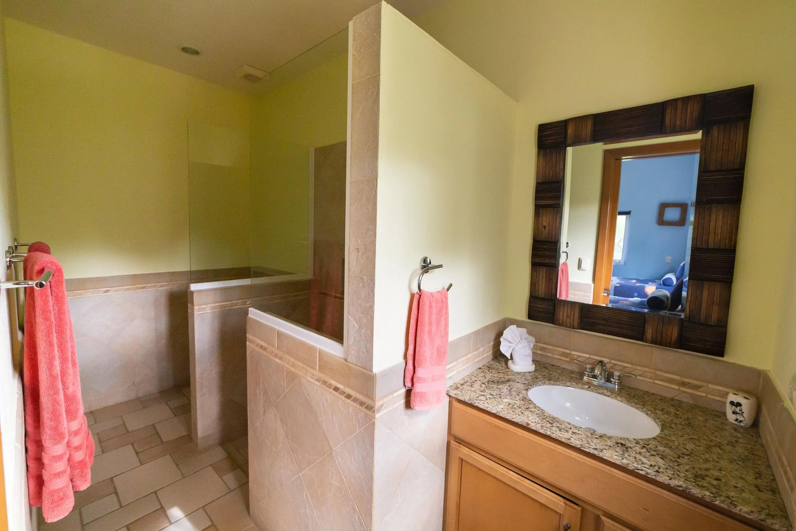 Second villa bathroom with sink, mirror and shower area