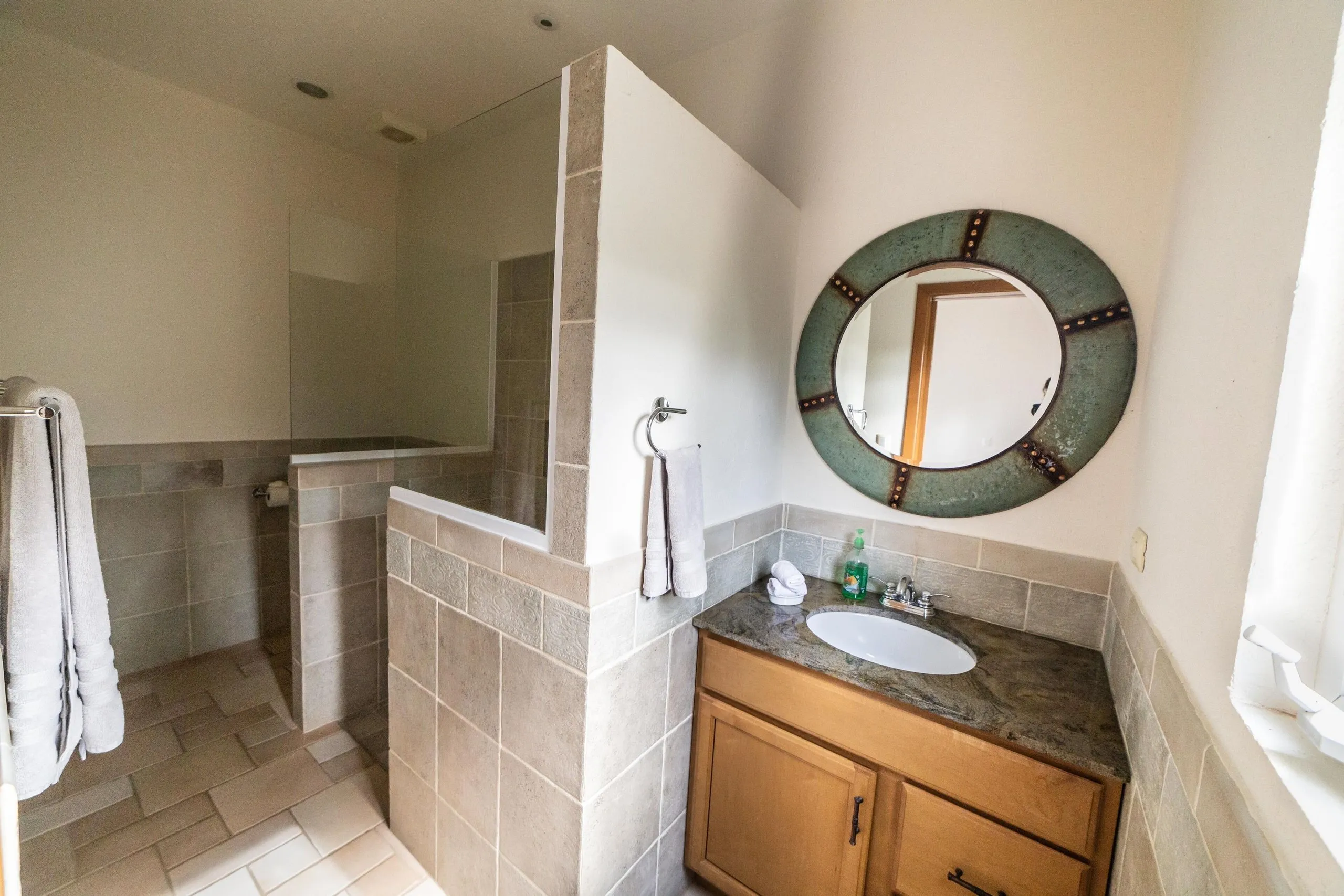 Villa bathroom with vanity sink, mirror and walk-in shower