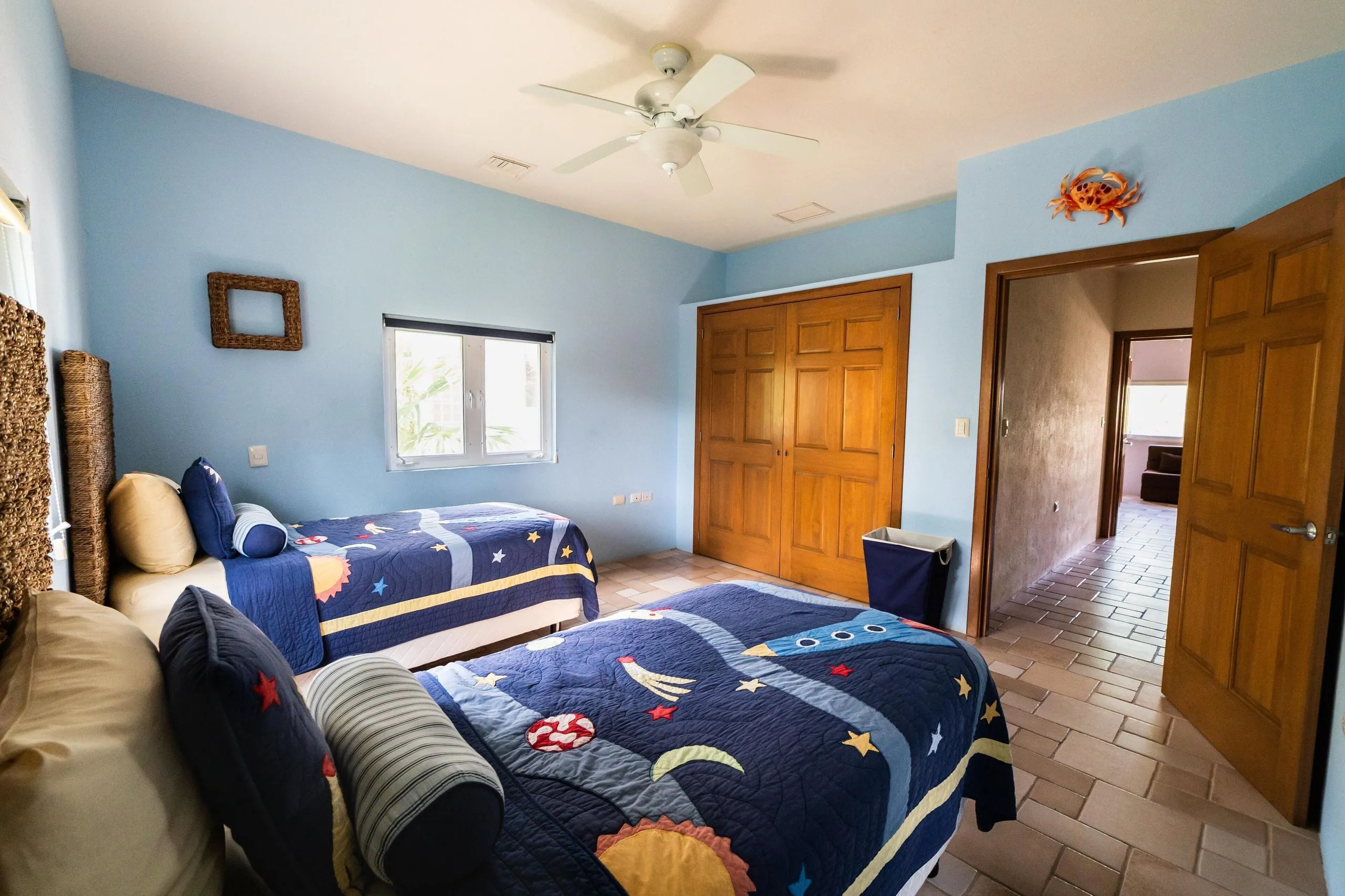 Twin bedroom with two beds, ceiling fan and a door through to the adjoining bathroom