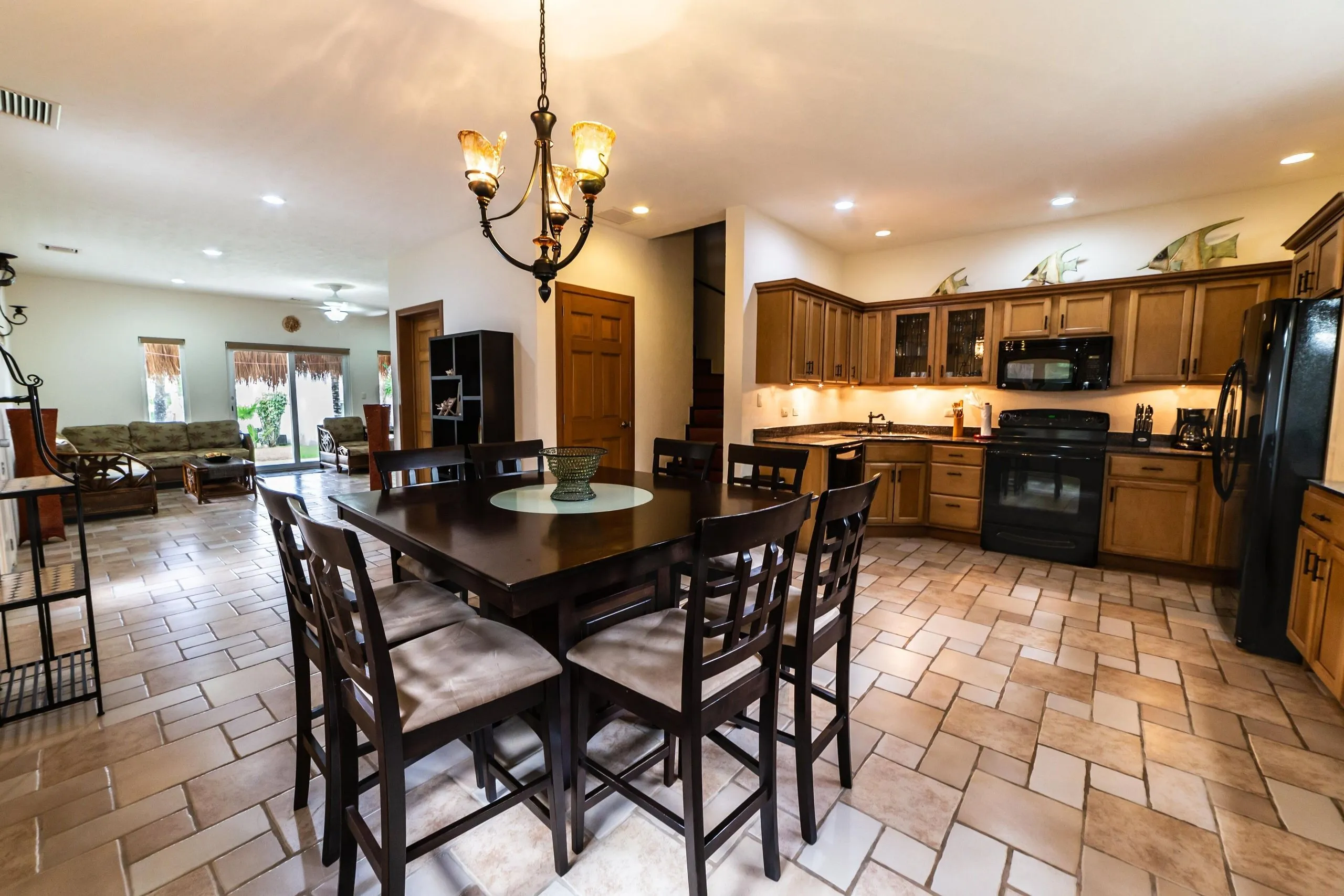 Spacious villa kitchen with a large island, wooden cabinetry and full-size refrigerator