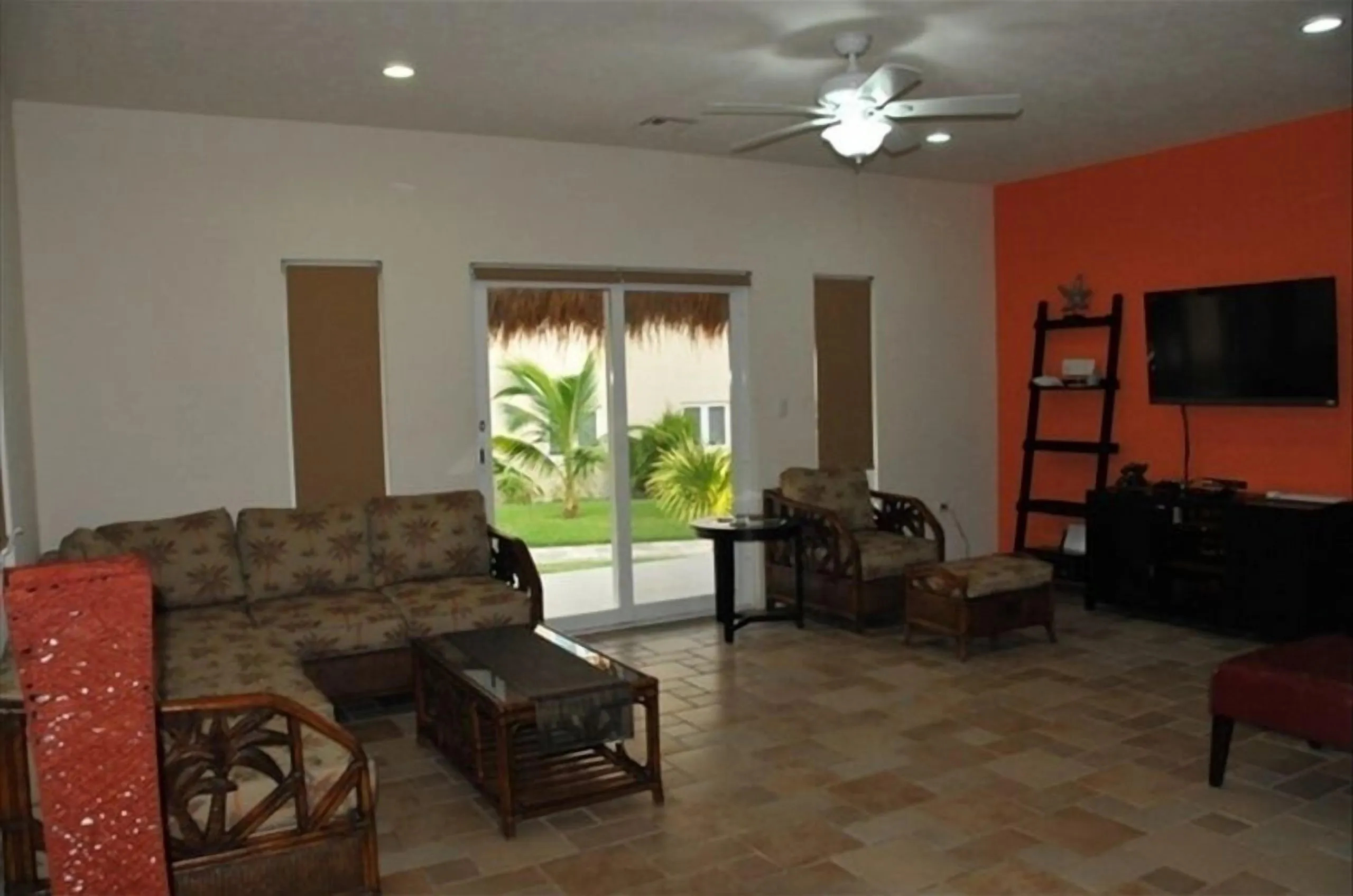 Sitting room with sofa, chairs, coffee table, television and ceiling fan